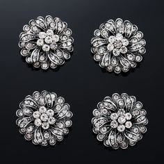 three pairs of brooches on a black background, each with different sized and color stones