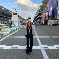 a woman standing in the middle of a race track