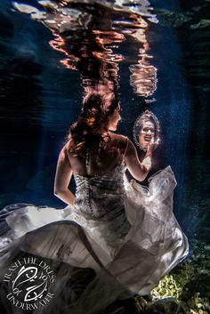 a woman in a white dress under water