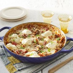 a casserole dish with meat, cheese and sauce in it on a table