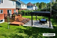 an outdoor patio with steps, table and grill area in the back yard on a sunny day