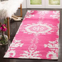 a bright pink rug with white snowflakes on it in front of a door