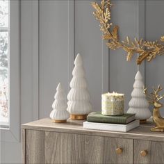 white and gold christmas decorations on top of a dresser