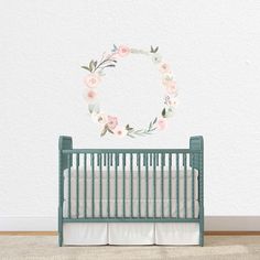 a baby's room with a crib and flower wall decal