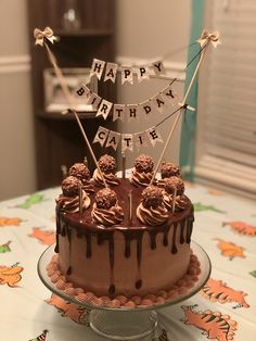 a birthday cake with chocolate icing and decorations on top is sitting on a table