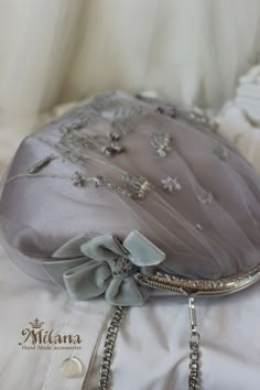 the purse is adorned with silver beads and bows