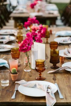 the table is set with flowers and place settings