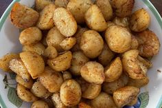 a white bowl filled with fried potatoes on top of a table