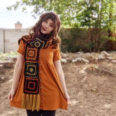 a woman in an orange dress is standing outside