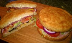 two sub sandwiches cut in half on a cutting board