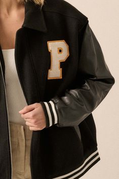 Felt and faux leather varsity bomber jacket. Flowers and letter "P" chenille applique patches. Contrasting faux leather sleeves. Side pockets with faux leather trim. Collared neckline. Zip-up front closure with snaps at top and bottom. Long sleeves. Dropped shoulders. Striped ribbed knit cuffs and hem. Yoke back. Quilted lining. Loose fit. 80% Polyester, 20% Cotton. Imported. Designed in LA. Model wears size S. Black Outerwear With Letter Embroidery For Fall, Black Fall Outerwear With Letter Embroidery, Fall Black Outerwear With Letter Embroidery, Black Letter Embroidery Outerwear For Fall, Fall Varsity Jacket For Campus, Oversized Fall Varsity Jacket For College, Fall Varsity Jacket With Baseball Collar, Varsity Jacket With Patches And Baseball Collar For Fall, Varsity Jacket With Baseball Collar For Fall