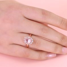 a woman's hand with a pink diamond ring on it