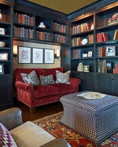 a living room filled with lots of bookshelves next to a couch and ottoman