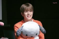 a boy holding a stuffed animal in his arms