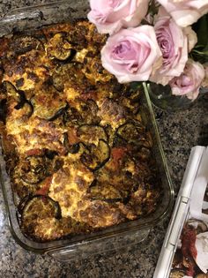 a casserole dish on a table with pink flowers