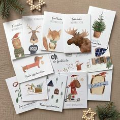 christmas cards with illustrations of animals and people on them, surrounded by pine cones and berries