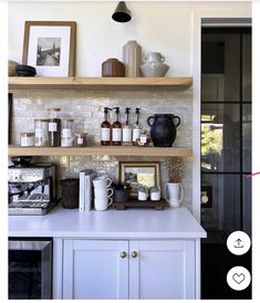 a kitchen with shelves filled with coffee cups and mugs on top of it's counter