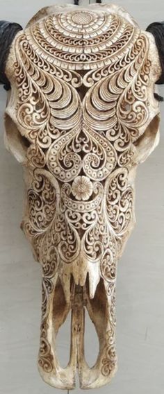 an intricately carved bull's head hangs on the wall