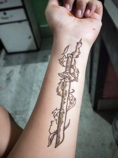 a person with a tattoo on their arm holding a knife in one hand and an arrow in the other