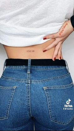 a woman's stomach with the words love me tattooed on her lower back and bottom