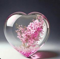 a heart shaped vase filled with pink flowers