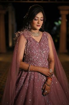 a woman wearing a purple dress and jewelry