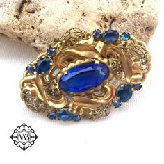 Beautiful vintage oval floral filigree Czech brass brooch with blue bohemian glasses. It is in a very good vintage condition. A rare and collectible piece. The size is: 3.5x5.5 cm This elegant large brooch could be a nice present for collectors or for beautiful brooch lovers. Please feel free to contact me if you have any questions. Check out my shop where you can find a lot of interesting brooches. Thank you for visiting my shop. Blue Oval Brooch Jewelry, Oval Blue Brooch Jewelry, Elegant Blue Oval Brooches, Elegant Oval Blue Brooches, Oval Blue Brooch, Blue Oval Brooch For Gifts, Blue Oval Brooch, Vintage Blue Jewelry Brooch, Vintage Sapphire Brooch Jewelry