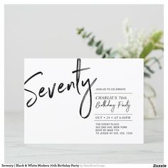 a white card with the word seventy written in black ink on it next to some flowers