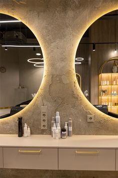 a bathroom with two circular mirrors above the sink and several bottles in front of it