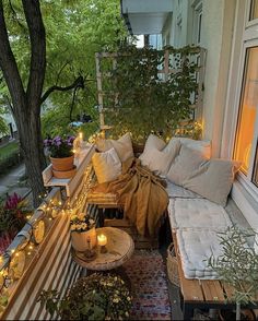 a balcony with lots of plants and lights on the windowsill, along with two couches