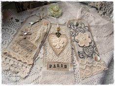 several pieces of lace on top of a white doily with flowers and hearts in the middle