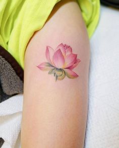 a woman's arm with a pink flower tattoo on the left side of her body