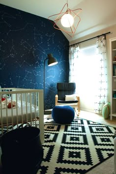 a baby's room decorated in blue and white with stars on the wall, crib, rocking chair, and rug