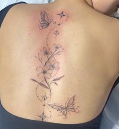 the back of a woman's shoulder with flowers and butterflies on her left side