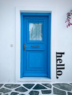 a bright blue door with the word hello painted on it