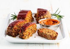 some meatloaf on a white plate with dipping sauce