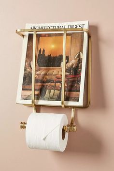 a toilet paper dispenser mounted to a wall with a magazine on it