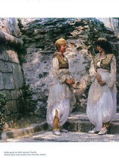 two women in white dresses standing on steps