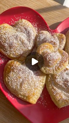 a red plate topped with powdered sugar covered pastries