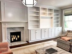 a living room with a couch, chair and bookcases in front of a fireplace