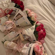 flowers and newspapers laid out in a circle on a bed with white linens,