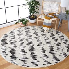 a white and black rug in a living room next to a chair with a potted plant on it