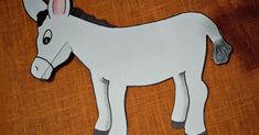 a paper cut out of a donkey on top of a wooden table with an orange background