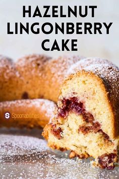 a close up of a bundt cake with powdered sugar on top and the words hazlenut lingonberry cake above it