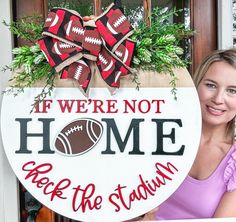 a woman standing next to a sign that says, if we're not home back the stadium