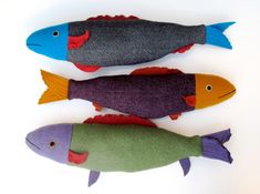 three fish made out of felt sitting next to each other