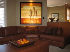 a living room filled with furniture and a large painting on the wall above it's coffee table