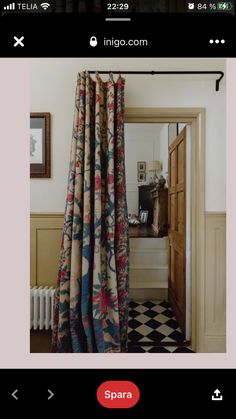 an open door with curtains hanging from it's side in front of a checkered floor