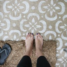 a person standing on top of a rug with their feet up