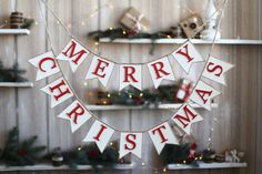 a merry christmas banner hanging on the wall in front of shelves with presents and decorations